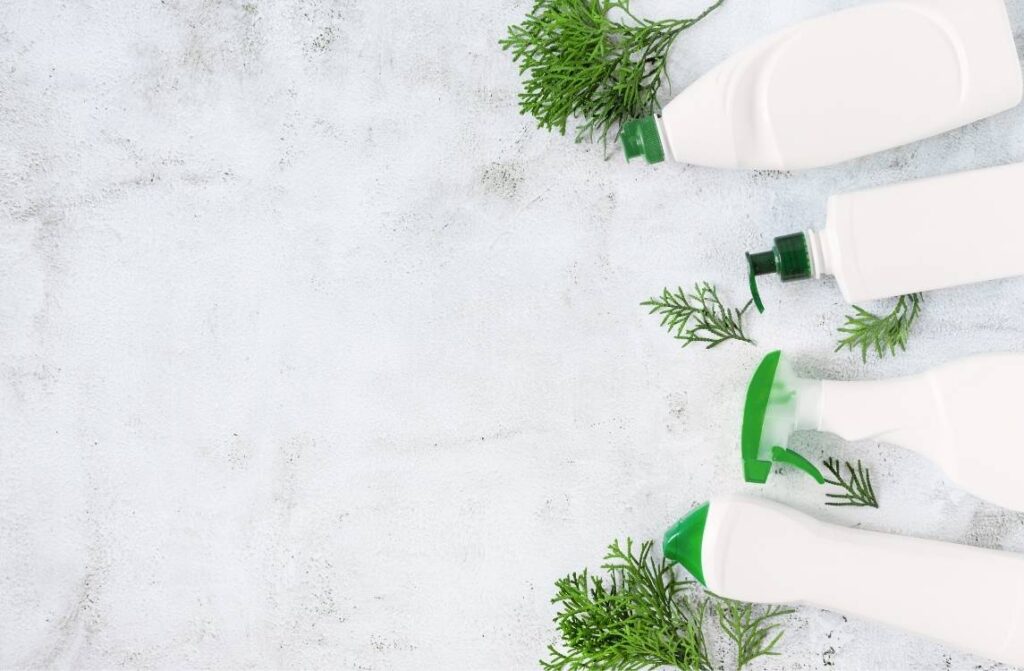 Botellas de limpiador y esponjas sobre un fondo blanco